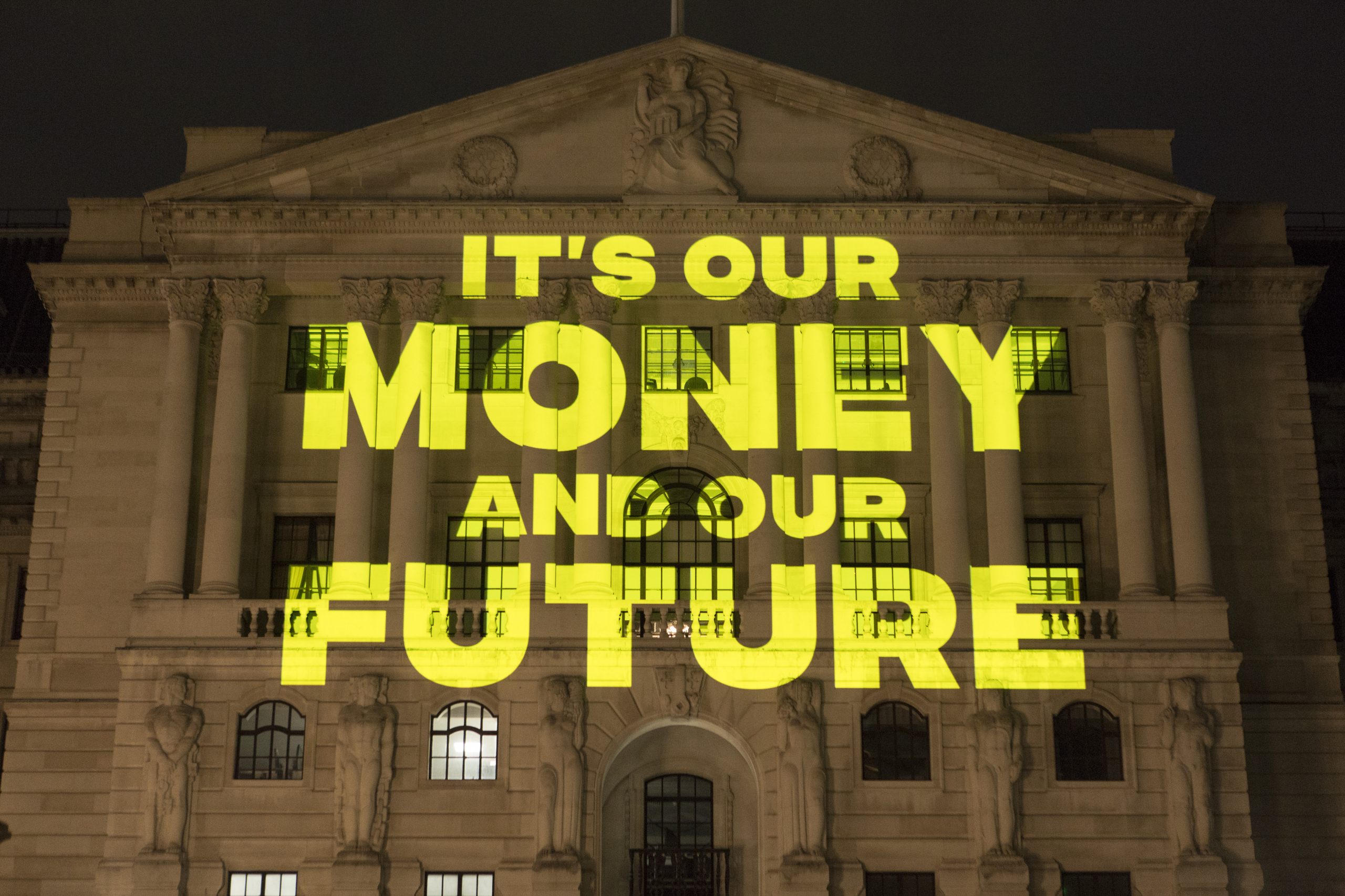 Projection on the Bank of England building reads 'It's our money and our future'