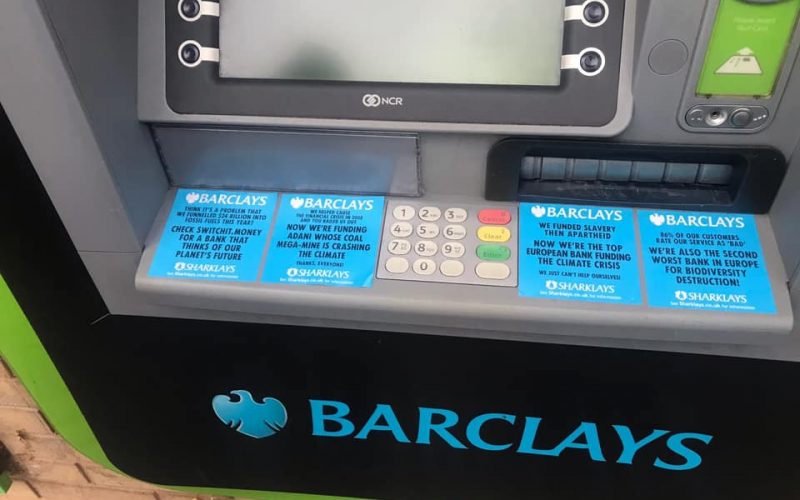Protest stickers on a Barclays cash macine