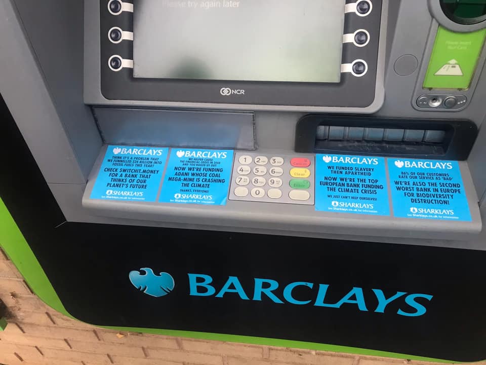 Protest stickers on a Barclays cash macine
