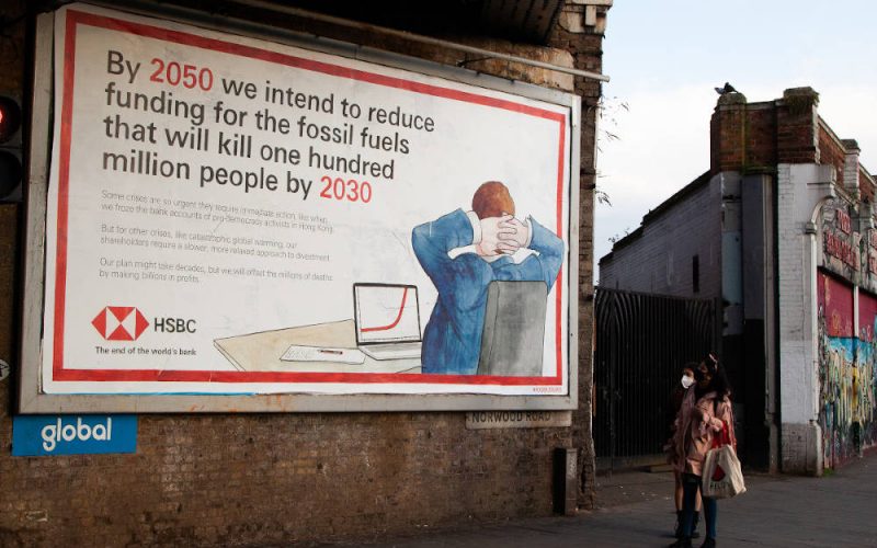 A passer-by looks at a spoof HSBC billboard advert